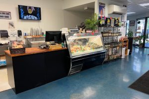 Interior photo of Sierra Gold Seafood market. there are shelves of various products. There is a display case with a variety of seafood. There is a register to the left.