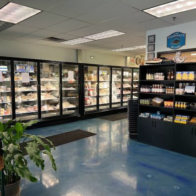 Interior photo of Sierra Gold Seafood market. there are shelves of various products. There are also freezers with a variety of products.