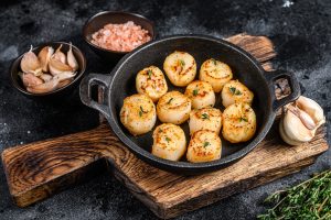 Fried,Scallops,With,Butter,Sauce,In,A,Pan.,Black,Background.